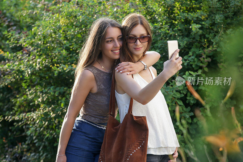 Two women taking a selfie in the park, Female friends having fun on the summer day in the city两个女人在公园里自拍，女性朋友在城市里玩夏天的一天